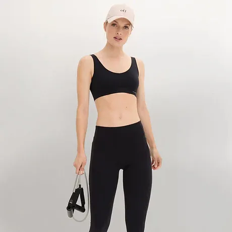 Soutien-gorge et legging de sport noirs et casquette blanche.
