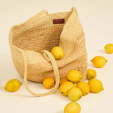Sac cabas en paille avec des citrons frais.