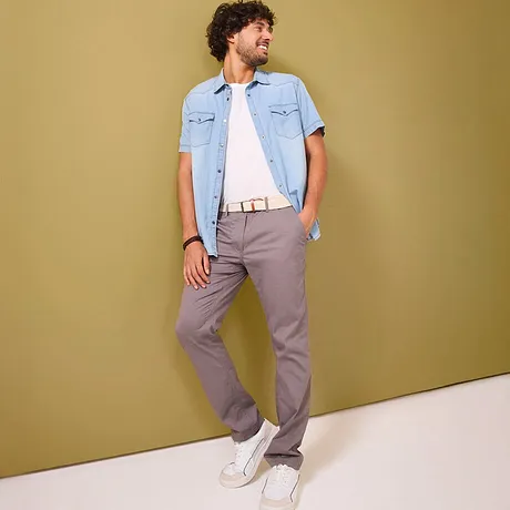 Graue Chinohose kombiniert mit einem hellblauem Jeanshemd.