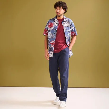 Buntes Hawaiihemd über rotem T-Shirt & dunkle Hose.