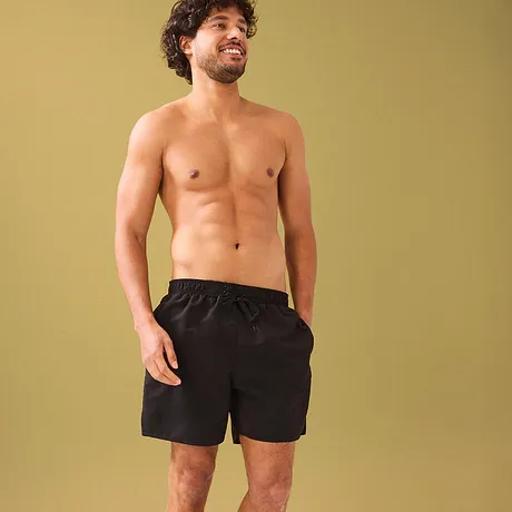 Schwarze Badeshorts betonen die athletische Figur.