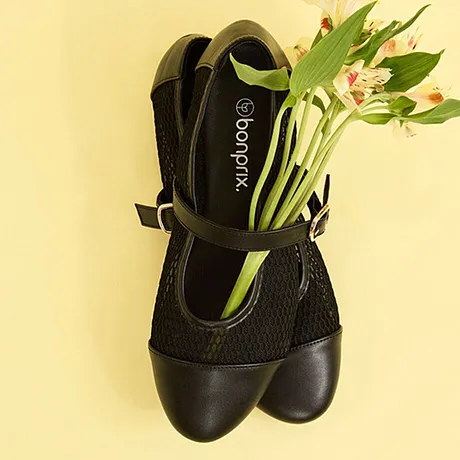 Chaussures femme noires avec bride et tissu résille, garnies de fleurs coupées. 