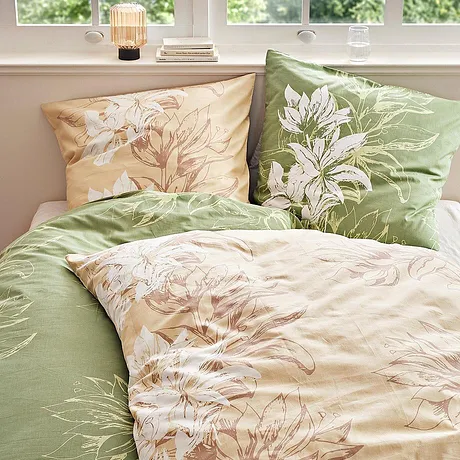 Parures de lit à fleurs dans des tons pastel : le vert et le beige avec les motifs floraux délicats apportent une touche déco sur le lit.