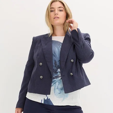 Marineblauer Blazer über blau gemustertem Oberteil.