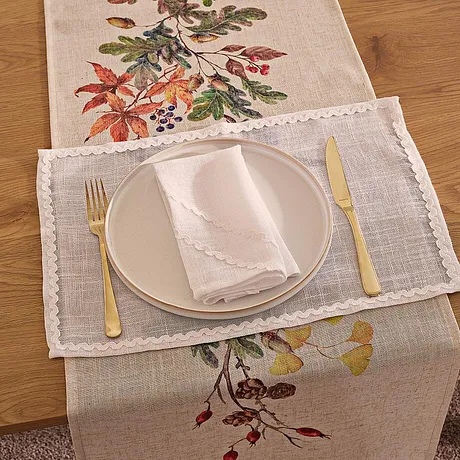 Herbstlicher Tischläufer mit bunten Blättern schmückt den gedeckten Tisch für eine gemütliche Mahlzeit.