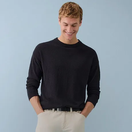 Eleganter schwarzer Rollkragenpullover kombiniert mit olivgrüner Cordhose.