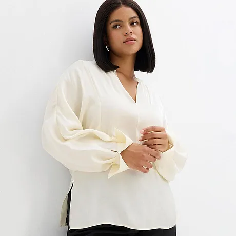 Elegante weiße Bluse mit V-Ausschnitt und weiten Ärmeln.