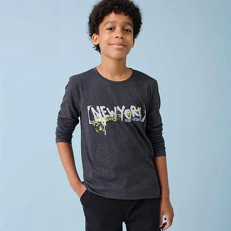 T-shirt foncé à manches longues avec imprimé graphique, porté avec un pantalon noir dans un style décontracté.