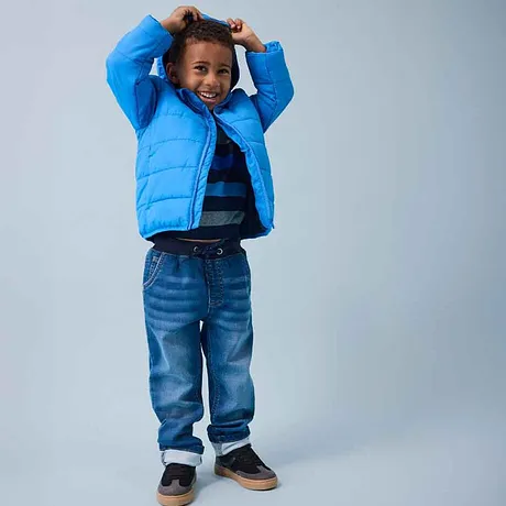 Doudoune bleue, T-shirt rayé et jean - la mode enfant joyeuse et pétillante pour affronter le froid.