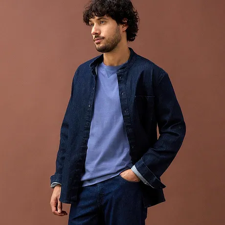 Chemise en jean bleu foncé et T-shirt bleu clair complétés d'un pantalon bleu foncé.