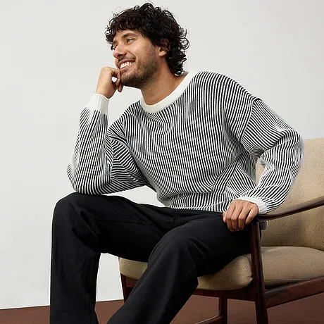 Pull rayé associé à un pantalon noir.