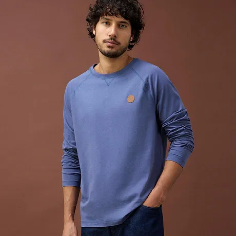 T-shirt bleu à manches longues et col rond avec petit logo sur la poitrine.