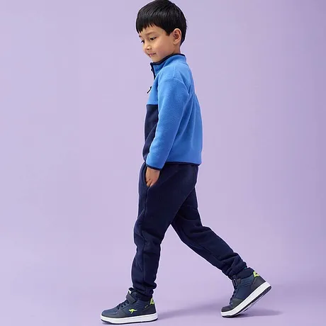 Veste en polaire bleue, jean foncé et baskets bleu marine.