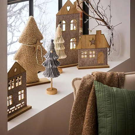 Décoration de Noël cosy dans des tons marron chauds sur le rebord de fenêtre.