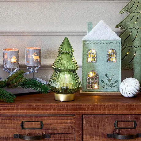 Illuminations de Noël avec maisonnette, bougies et sapin vert.