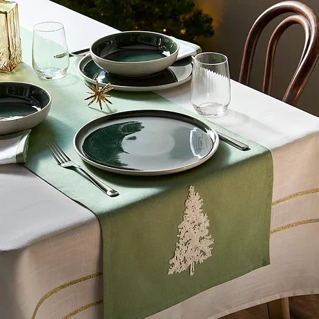 Chemin de table vert avec sapin brodé pour apporter une touche déco festive à la table de Noël. 