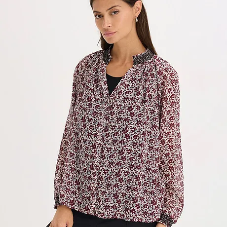 Blouse à motif floral en noir, rouge et blanc.