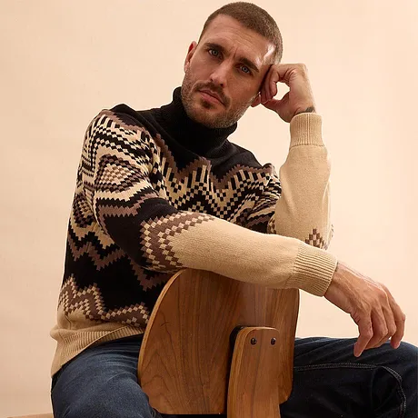 Pull chaud à motif géométrique et jean bleu.