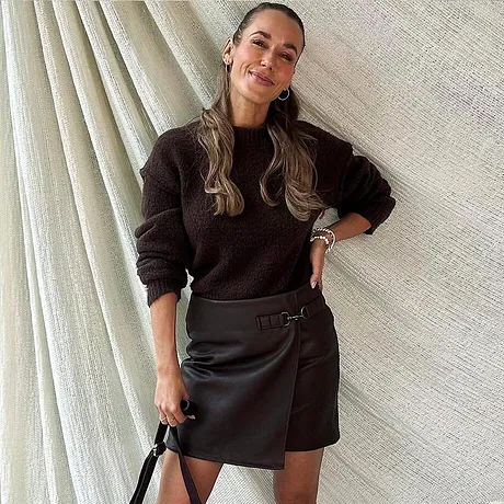 Annemarie Carpendale trägt einen brauen Pullover und brauen Rock.