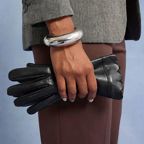 Bracelet couleur argentée et gants noirs.