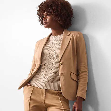Blazer beige associé à un pull en maille couleur crème.