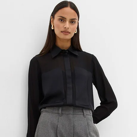 Chemisier noir associé à un pantalon gris.