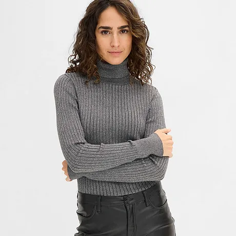 Pull gris à col roulé associé à un pantalon noir enduit.