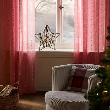 Rideaux rose encadrant la fenêtre.