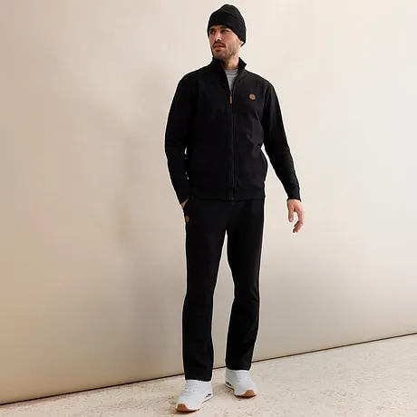 Survêtement noir avec bonnet et baskets blanches.