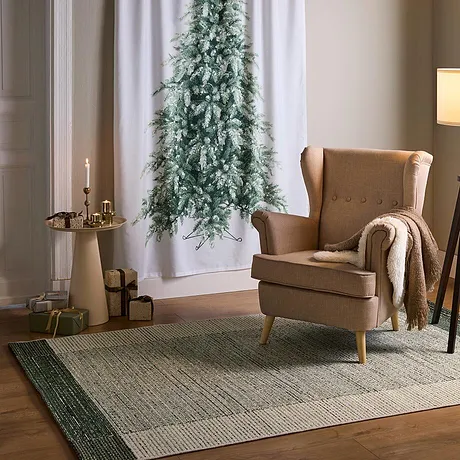 Un fauteuil à oreilles et une table d'appoint avec des lumières de Noël.