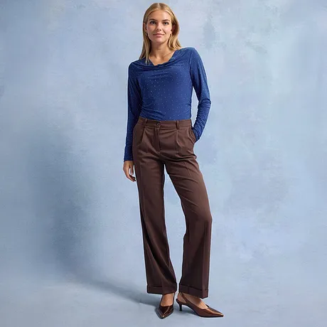 Blaues Langarmshirt mit Punkten, braune Hose mit weitem Bein und spitze braune Schuhe.