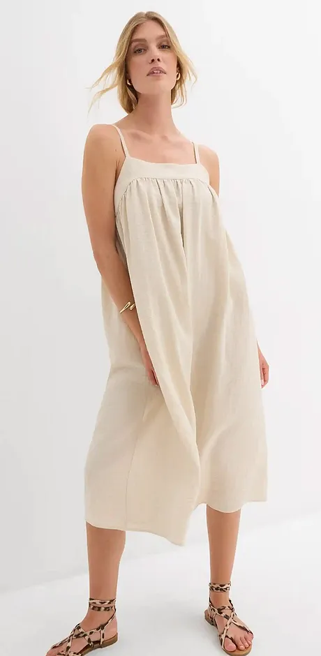Robe d’été beige avec de fines bretelles. Coupe ample, longueur genou et tissu léger.