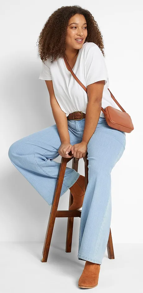 T-shirt blanc à encolure dégagée, jean clair et petit sac marron. 