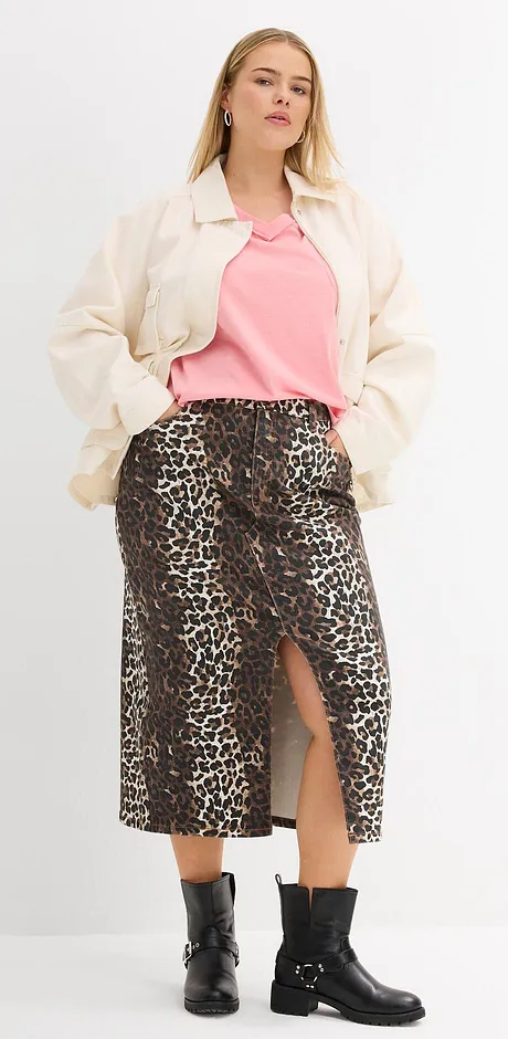 Veste de couleur crème, T-shirt rose, jupe à motif léopard et bottes noires pour un look stylé.