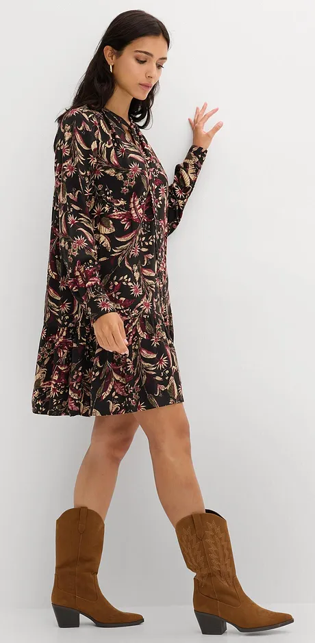 Florale Musterung auf schwarzem Kleid, kombiniert mit braunen Cowboystiefeln.