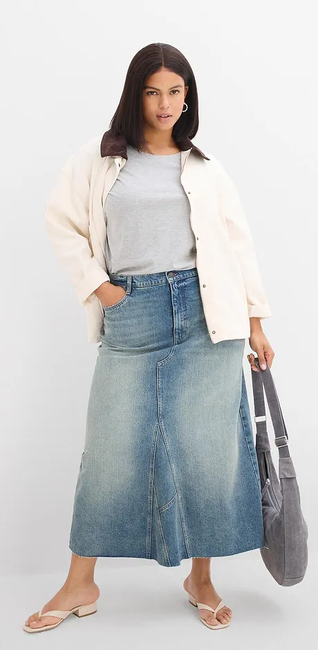 Flauschige weiße Jacke, graues Top, langer Jeansrock und bequeme Sandalen.