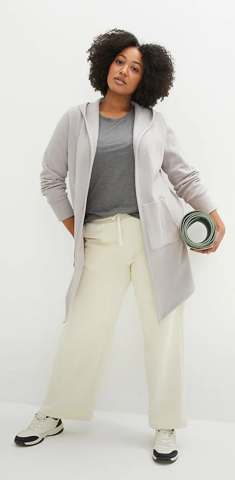 Sweatjacke, T-Shirt und cremefarbene Hose für einen sportlichen Look.