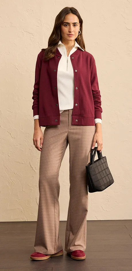 Tenue composée d'un gilet en maille rouge bordeaux, un haut blanc et un pantalon à carreaux.