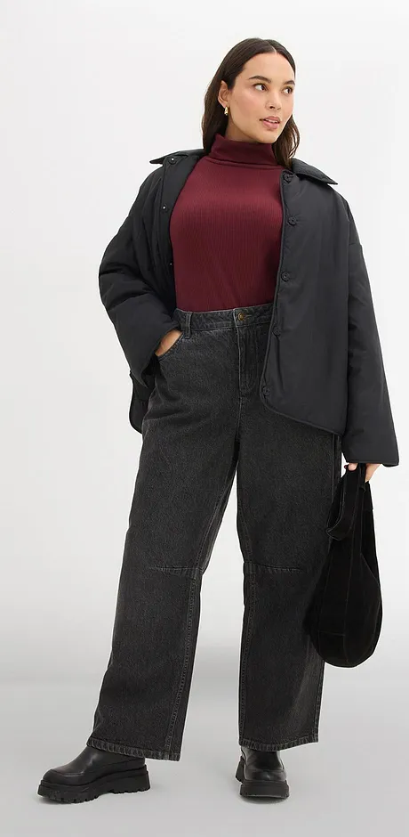 Kombination aus burgunderrotem Rollkragenpullover, schwarzerJacke und schwarzer Jeans.