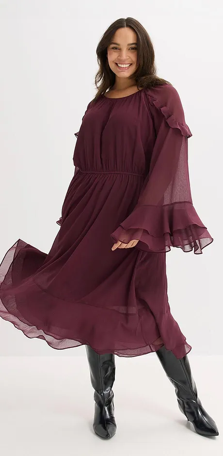 Bordeauxrotes Kleid mit fließendem Stoff, weiten Ärmeln und schwarzen Stiefeln.