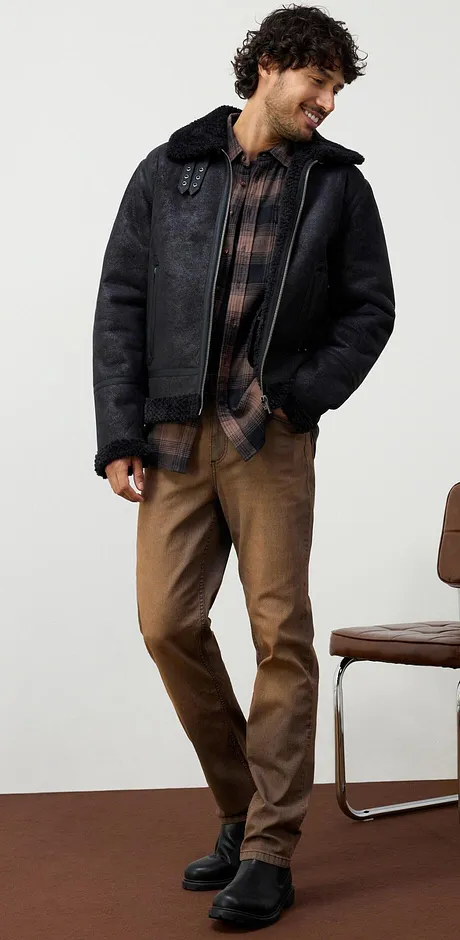 Jean marron décontracté, chemise à carreaux et bottines noires.