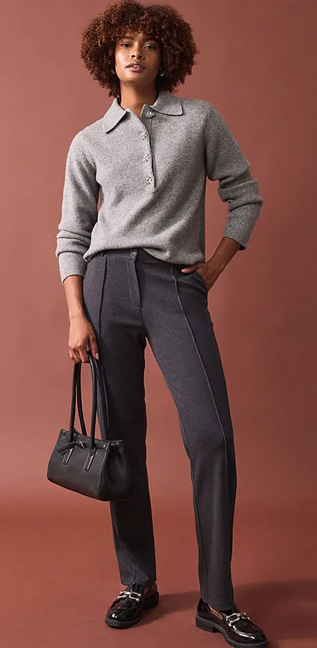 Pull gris élégant associé à un pantalon de tailleur chic et des mocassins noirs.