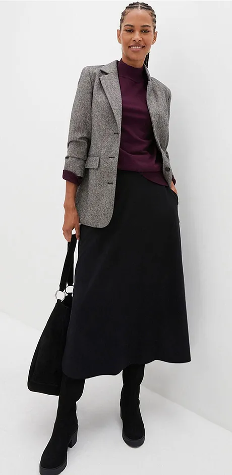 Blazer à carreaux, haut violine et jupe longue noire.