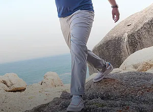 Pantalon en toile gris clair associé à des baskets claires.