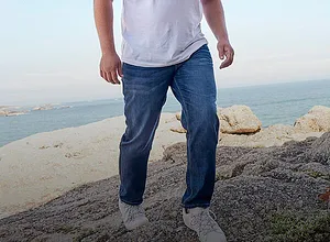 Jean bleu clair, complété d'une paire de tennis blanches confortables.