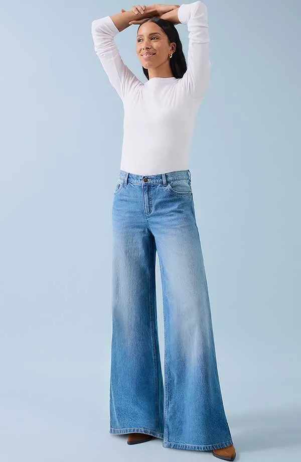 Weißes Langarmshirt und weite Jeans: eine Kombination aus Komfort und lässigem Stil.