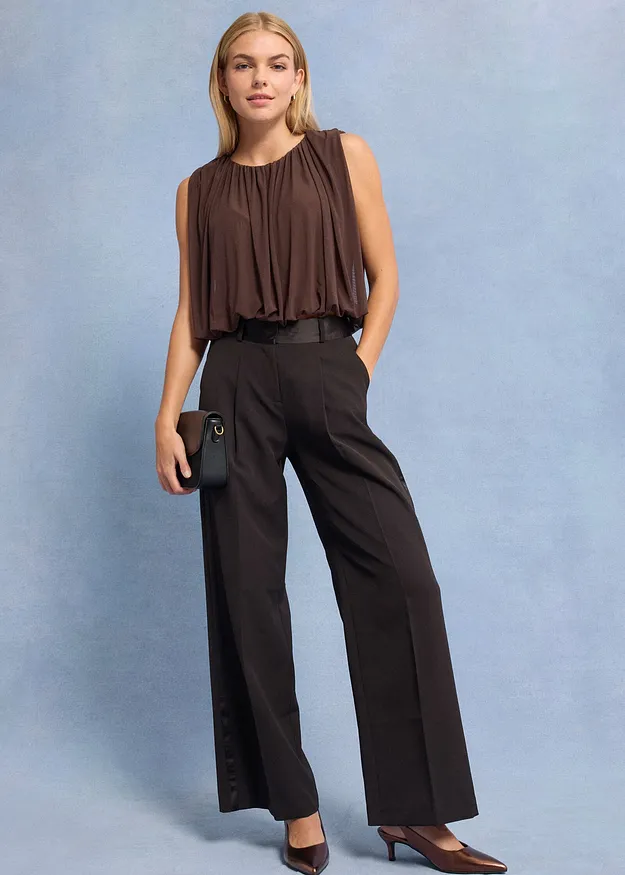  Braunes &auml;rmelloses Top und weite, dunkle Hose. 