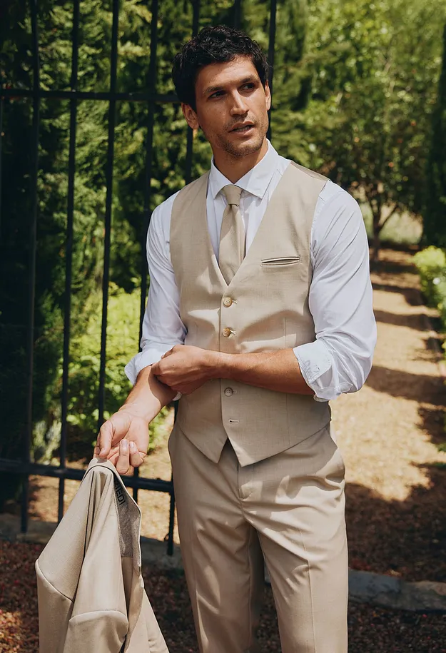 Gilet sans manches, pantalon et veste. Une chemise blanche et une cravate finalisent la tenue.