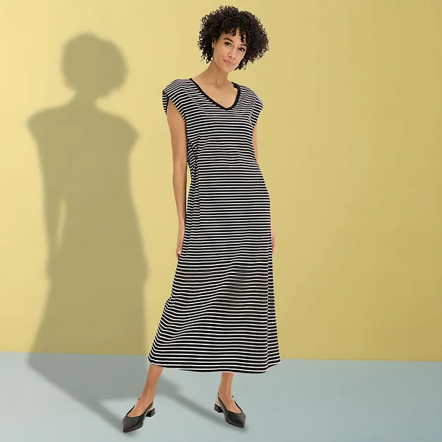 Elegantes schwarz-wei&szlig; gestreiftes Maxikleid mit V-Ausschnitt und schwarzen Ballerinas.