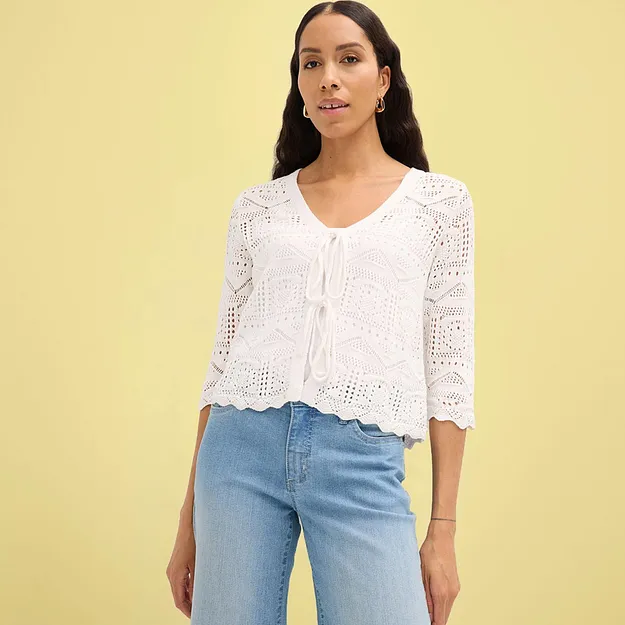 Wei&szlig;e geh&auml;kelte Strickjacke mit halblangen &Auml;rmeln kombiniert mit blauer Jeans.